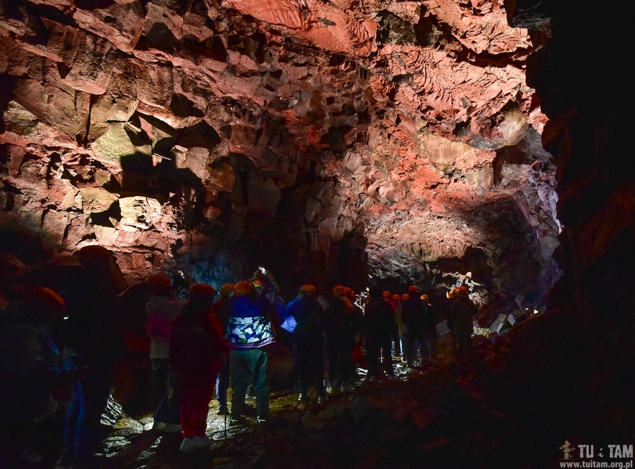Trekking w głębi jaskini lawowej na Islandii z oświetleniem czołówkami